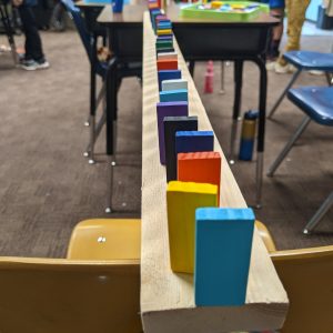 Multi-colored dominos lined up across a narrow board