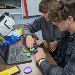 two male students working together on a Makey Makey project. 