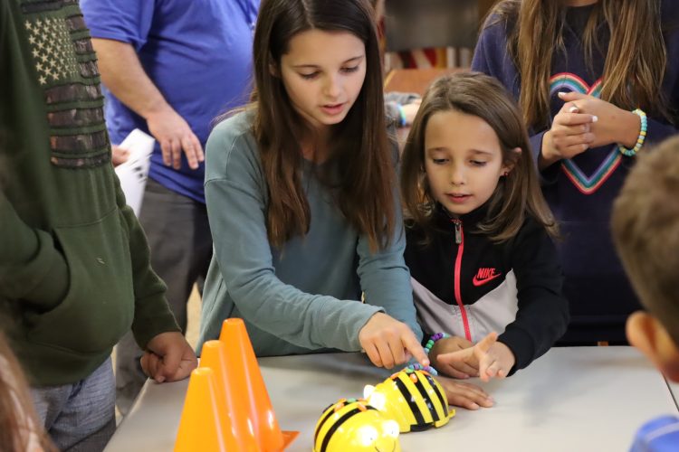 Two female students programming a BeeBot robot