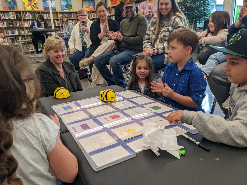 Students and their teacher demonstrate how they are using Bee Bots to learn how to code.
