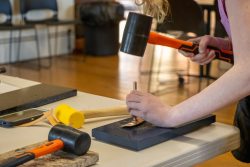 Student works to press a pattern into their leather tooling project"